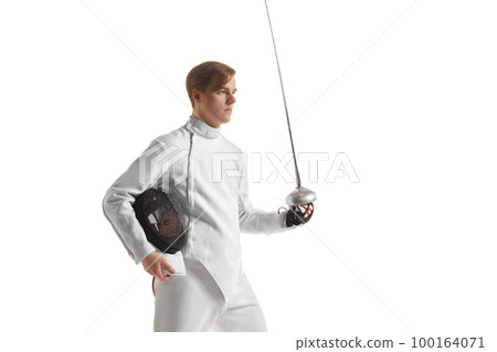 Young man, male fencer in fencing costume mask standing with sword over white studio background. Sport, motivation, professional skills 100164071