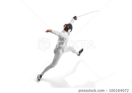 Dynamic portrait of male athlete in fencing costume with sword in hand in action isolated on white studio background. Dynamic portrait of male athlete in fencing costume with sword in hand in action isolated on white studio background. 100164072