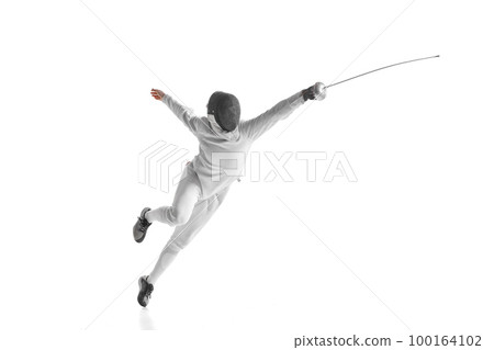 Professional male fencer in fencing costume training with sword isolated on white studio background. Concept of sport, competition, professional skills, achievements 100164102