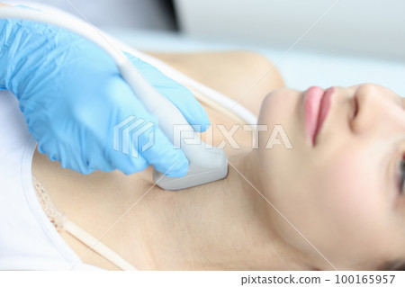 Scanning the thyroid gland of woman in medical clinic closeup Scanning the thyroid gland of woman in medical clinic closeup 100165957