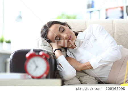 Beautiful young woman sleeps serenely on couch Beautiful young woman sleeps serenely on couch 100165998