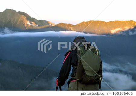 a traveler boy standing on mountain while travelling  100166466