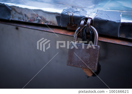 一把生鏽的鎖被放在一個大盒子裡的城市景觀 一把生鏽的鎖被放在一個大盒子裡的城市景觀 100166621