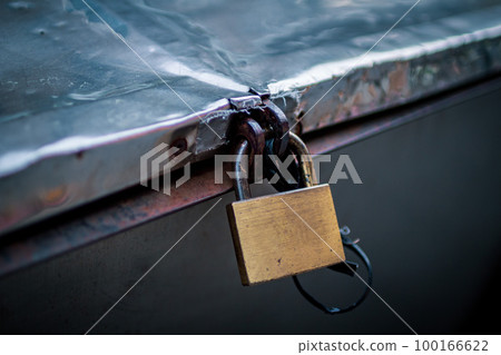 An urban landscape where a rusty lock is placed in a large box 100166622