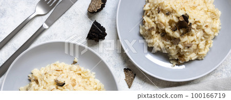 Risotto with porcini mushrooms and black truffles served in a plate top view, gourmet cousine 100166719