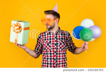 look here. preparation and celebration. party fun. shopping sale. happy birthday guy in checkered shirt. stylish male with holiday accessory. bearded man with bristle hold balloons and present box look here. preparation and celebration. party fun. shopping sale. happy birthday guy in checkered shirt. stylish male with holiday accessory. bearded man with bristle hold balloons and present box 100166765