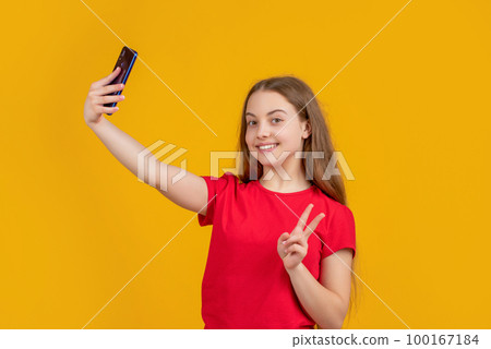 happy kid with smartphone on yellow background. peace happy kid with smartphone on yellow background. peace 100167184
