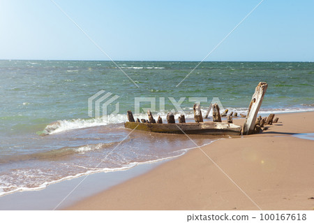 remains of old boat on shore. wooden longtail covered by sand. Travel landscape tropical sea beach 100167618
