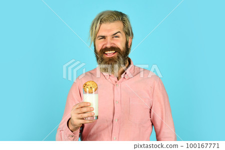 Soaking cookie on milk. happy farmer eat cookie dessert. bearded man drink useful milk with pastry. Christmas food and drink. Christmas cookies and milk. Cold Christmas coziness concept Soaking cookie on milk. happy farmer eat cookie dessert. bearded man drink useful milk with pastry. Christmas food and drink. Christmas cookies and milk. Cold Christmas coziness concept 100167771