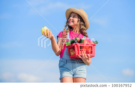 Child carry harvest sky background. Crops harvest. Harvest season. Vegetables in basket. Girl adorable child farming. Homegrown veggies. Organic food. Sunny day at farm. Natural vitamin nutrition Child carry harvest sky background. Crops harvest. Harvest season. Vegetables in basket. Girl adorable child farming. Homegrown veggies. Organic food. Sunny day at farm. Natural vitamin nutrition 100167952