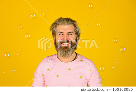Happiness and joy. Good mood. Play with bubbles. Forever young guy. Positive. Carefree man soap bubbles. Summer vacation. Infantility concept. Happy playful bearded hipster and soap bubbles Happiness and joy. Good mood. Play with bubbles. Forever young guy. Positive. Carefree man soap bubbles. Summer vacation. Infantility concept. Happy playful bearded hipster and soap bubbles 100168090