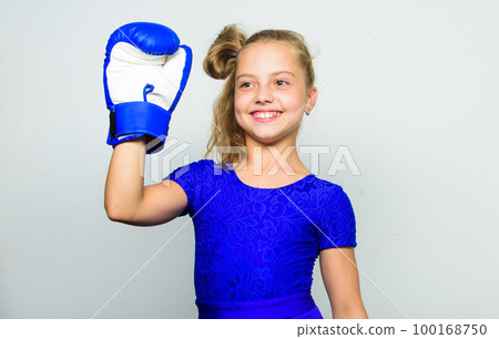 Sport upbringing for girls. Feminist movement. Strong child concept. Kid strong and healthy. Girl child strong with boxing gloves posing on grey background. She feels strong and independent girl 100168750