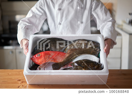 Chef with fresh fish delivered from the production area Chef with fresh fish delivered from the production area 100168848