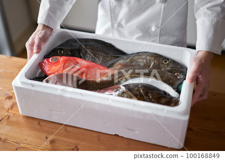 Chef with fresh fish delivered from the production area 100168849