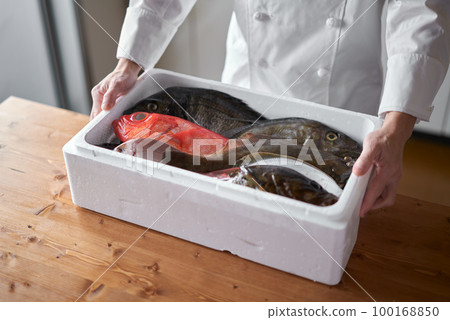 Chef with fresh fish delivered from the production area 100168850