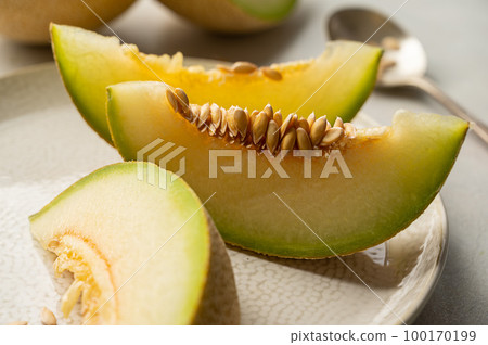 Cantaloupe, melon fruit slice over bright background. 100170199