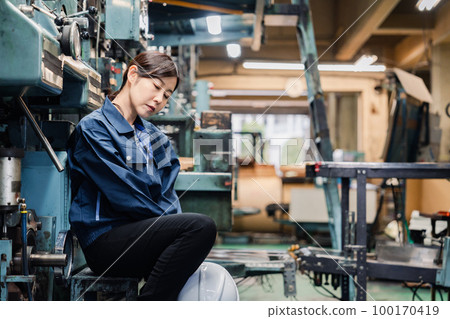 A female factory worker who is overworked and unmotivated A female factory worker who is overworked and unmotivated 100170419