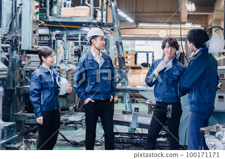 Factory workers having a friendly chat during break time Factory workers having a friendly chat during break time 100171171