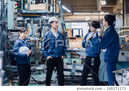 Factory workers having a friendly chat during break time Factory workers having a friendly chat during break time 100171173