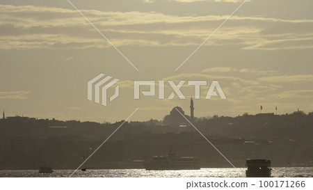 Foggy landscape. Action.A beautiful morning on the sea where seagulls fly from above,the sun shines,floating ships and towers on the coast are visible. 100171266