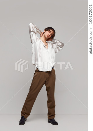 Calmness and self-confidence. Portrait of stylish high fashionable boy posing isolated over grey background. Concept of modern fashion, uniqueness, ad Calmness and self-confidence. Portrait of stylish high fashionable boy posing isolated over grey background. Concept of modern fashion, uniqueness, ad 100172001