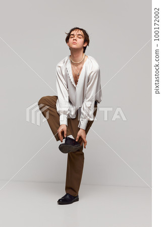 Fashion portrait of stylish high fashionable boy posing isolated over grey background. Concept of modern fashion, uniqueness, ad Fashion portrait of stylish high fashionable boy posing isolated over grey background. Concept of modern fashion, uniqueness, ad 100172002