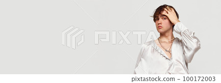 Stylish high fashion model, handsome young man posing isolated over grey background. Concept of modern fashion, uniqueness, ad 100172003