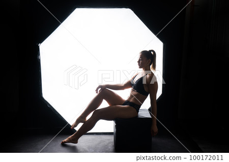 Silhouette of a beautiful young woman wearing underwear in backlight Silhouette of a beautiful young woman wearing underwear in backlight 100172011