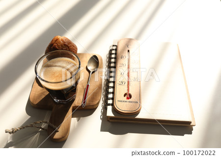 Flat lay Coffee and cup cake and notebook and thermometer with sunshine 100172022