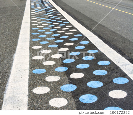 Pedestrian crosswalk on asphalt road colored with blue and white dots Pedestrian crosswalk on asphalt road colored with blue and white dots 100172232