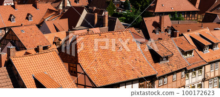 Scenic panoramic view traditional shingle tiled red rooftop old ancient medieval european german small town Quedlinburg church against blue sky background. Unesco heritage list travel destination Scenic panoramic view traditional shingle tiled red rooftop old ancient medieval european german small town Quedlinburg church against blue sky background. Unesco heritage list travel destination 100172623