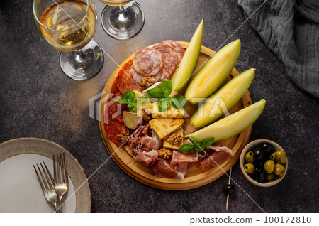 Charcuterie gourmet antipasti plater cheese, salami, prosciutto, melon board. Top view Charcuterie gourmet antipasti plater cheese, salami, prosciutto, melon board. Top view 100172810