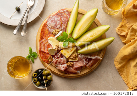 Charcuterie gourmet antipasti plater cheese, salami, prosciutto, melon board. Top view 100172812
