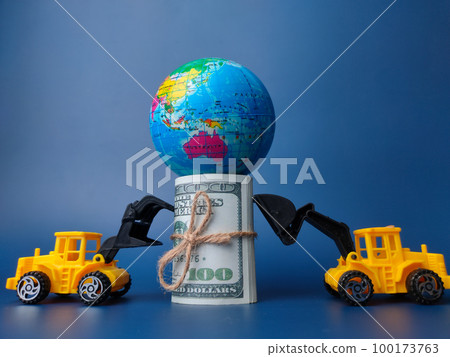 Excavator pushing banknotes and earth globe on blue background. Business concept. Excavator pushing banknotes and earth globe on blue background. Business concept. 100173763