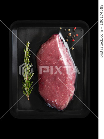 Fresh raw beef fillet steak sealed in vacuum tray with pepper and rosemary on black. Fresh raw beef fillet steak sealed in vacuum tray with pepper and rosemary on black. 100174588