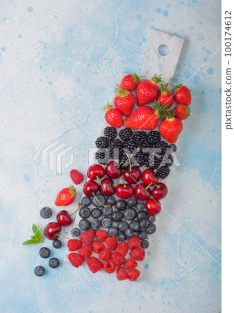 Fresh organic summer berries mix on white marble board on blue kitchen table background. Fresh organic summer berries mix on white marble board on blue kitchen table background. 100174612