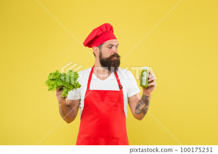 Drinking is more easy. Fresh juice. Squeezing smoothie. Man bearded chef hold lettuce and smoothie bottle yellow background. Vegetarian nutrition. Vitamin smoothie drink. Hipster smoothie beverage Drinking is more easy. Fresh juice. Squeezing smoothie. Man bearded chef hold lettuce and smoothie bottle yellow background. Vegetarian nutrition. Vitamin smoothie drink. Hipster smoothie beverage 100175231
