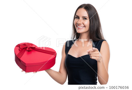 valentine woman with gift in studio, pointing finger. valentine woman with gift on background. valentine woman with gift in studio, pointing finger. valentine woman with gift on background. 100176036