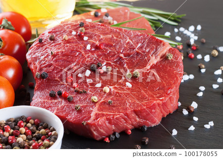 Fresh raw beef steak with spice on black background Fresh raw beef steak with spice on black background 100178055