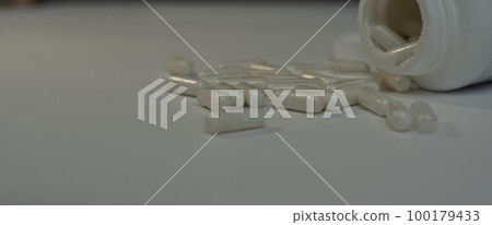 medical pills and capsule spilling from bottle on the white background medical pills and capsule spilling from bottle on the white background 100179433