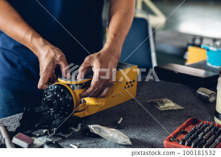 Engineer or technician assemble parts of new robot arms in the factory for modernization of production. Engineer or technician assemble parts of new robot arms in the factory for modernization of production. 100181532