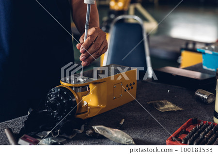 Engineer or technician assemble parts of new robot arms in the factory for modernization of production. Engineer or technician assemble parts of new robot arms in the factory for modernization of production. 100181533