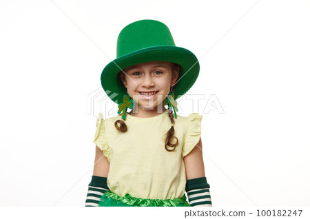 Adorable 5 years old Irish little child, funny Leprechaun girl in green carnival hat and earrings in the shape of clover leaves, smiling looking at camera over a white background. Saint Patrick's Day Adorable 5 years old Irish little child, funny Leprechaun girl in green carnival hat and earrings in the shape of clover leaves, smiling looking at camera over a white background. Saint Patrick's Day 100182247