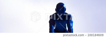 Bodybuilder working on his abs with a ab roller on studio background with color filter Bodybuilder working on his abs with a ab roller on studio background with color filter 100184609