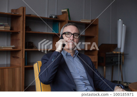 Portrait of elderly confident grey haired businessman in blue suit and eye glasses talking Portrait of elderly confident grey haired businessman in blue suit and eye glasses talking 100185971