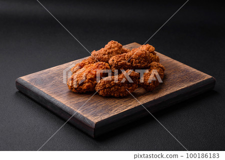 Delicious crispy breaded chicken wings grilled with spices and herbs 100186183