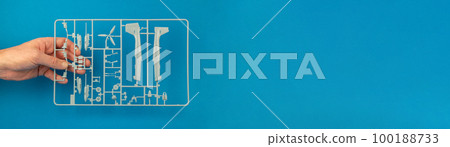 Parts tree of the airplane model in hand, banner. Sprue from a plastic model kit. Hobby of building model aircraft, model building 100188733