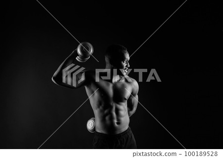Muscular black african man with defined muscles abs abdominal, exercise determination and success 100189528