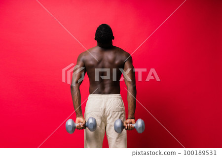 Muscular black african man with defined muscles abs abdominal, exercise determination and success 100189531