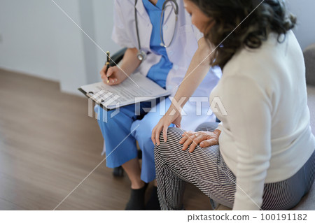 Portrait of a female doctor talking to a patient with knee pain Portrait of a female doctor talking to a patient with knee pain 100191182